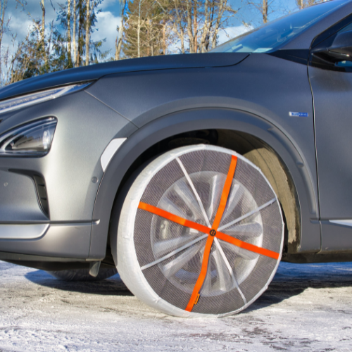 Vista lateral de un automóvil con calcetines de nieve AutoSock montados en las ruedas delanteras
