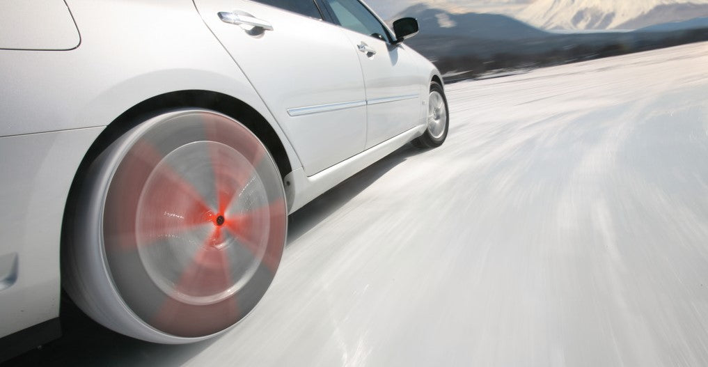 AutoSock montado en las ruedas delanteras de un automóvil, conduciendo sobre nieve y hielo en un paisaje invernal