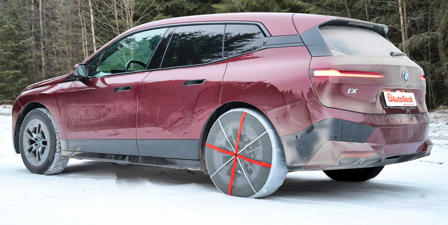 Vista trasera de las cadenas de nieve textiles AutoSock montadas en las ruedas traseras del BMW SUV iX
